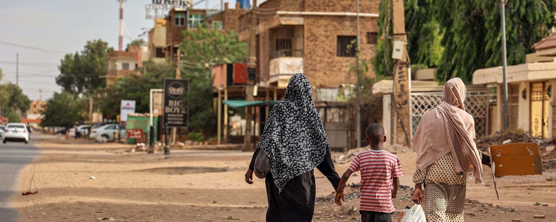 نساء وطفل يمشون على طول شارع في الخرطوم في 18 أبريل 2023 - سبوتنيك عربي, 1920, 25.08.2023