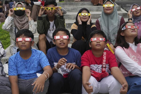 شبان إندونيسيون يرتدون نظارات واقية لمشاهدة كسوف الشمس في جاكرتا، إندونيسيا، الخميس 20 أبريل 2023. - سبوتنيك عربي