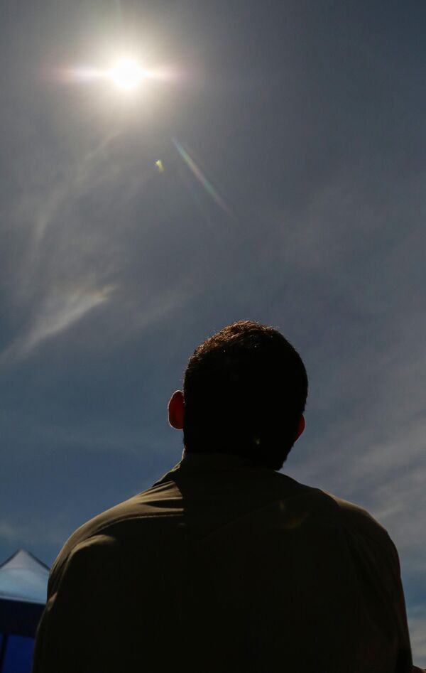 الناس يشاهدون كسوفًا للشمس باستخدام نظارات خاصة في ديلي في 20 أبريل 2023. - سبوتنيك عربي