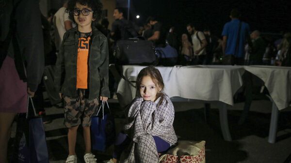 أطفال تم إجلاؤهم من السودان ينتظرون بعد وصولهم إلى مطار عسكري في عمان في 24 أبريل 2023.  - سبوتنيك عربي
