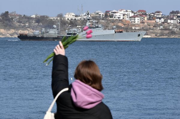 فتاة تلوح من الجسر إلى سفينة عسكرية تابعة لأسطول البحر الأسود في سيفاستوبول، القرم 8 مارس 2023 - سبوتنيك عربي