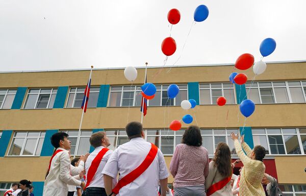 الخريجون يطلقون بالونات بألوان العلم الروسي الثلاثة في حفل &quot;الجرس الأخير&quot; في مدرسة ماريوبول الثانوية &quot;رقم 65&quot;. - سبوتنيك عربي