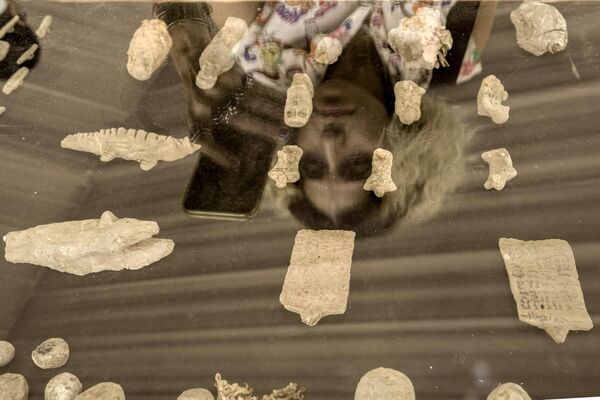 تنعكس الزائرة على لوحة وُضعت عليها قطع أثرية اكتُشفت مؤخرًا، أثناء تصويرها في موقع هرم زوسر المدرج في سقارة، على بعد 24 كيلومترًا (15 ميلًا) جنوب غرب القاهرة، مصر،  27 مايو 2023. - سبوتنيك عربي