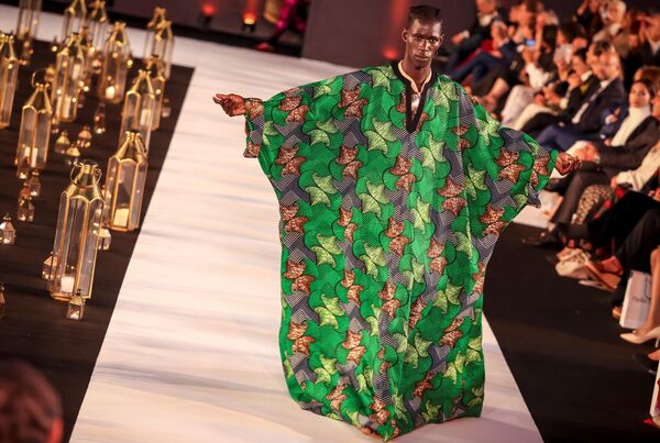 عارض أزياء يقدم  زيا من تصميم المصممة المغربية فضيلة الجادي خلال عرض أزياء في الرباط، المغرب 30 مايو 2023 - سبوتنيك عربي