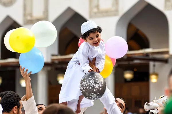 رد فعل صبي يحمل بالونات بينما يرفعه رجل بعد صلاة عيد الأضحى في الجامع الأزهر وسط القاهرة، مصر،28 يونيو 2023. رد فعل صبي يحمل بالونات بينما يرفعه رجل بعد صلاة عيد الأضحى في الجامع الأزهر وسط القاهرة، مصر،28 يونيو 2023. - سبوتنيك عربي