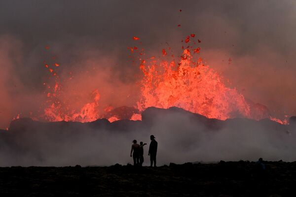 يشاهد الناس الحمم المتدفقة في أثناء الثوران البركاني بالقرب من ليتلي هروتور، جنوب غرب ريكيافيك في أيسلندا، 10 يوليو 2023. - سبوتنيك عربي