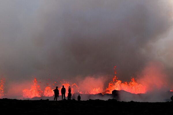 يشاهد الناس الحمم المتدفقة في أثناء الثوران البركاني بالقرب من ليتلي هروتور، جنوب غرب ريكيافيك في أيسلندا، 10 يوليو 2023. - سبوتنيك عربي