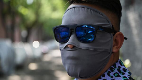 رجل يرتدي غطاء الوجه للحماية من أشعة الشمس أثناء ظروف الموجة الحارة في بكين، الصين في 20 يوليو 2023. - سبوتنيك عربي