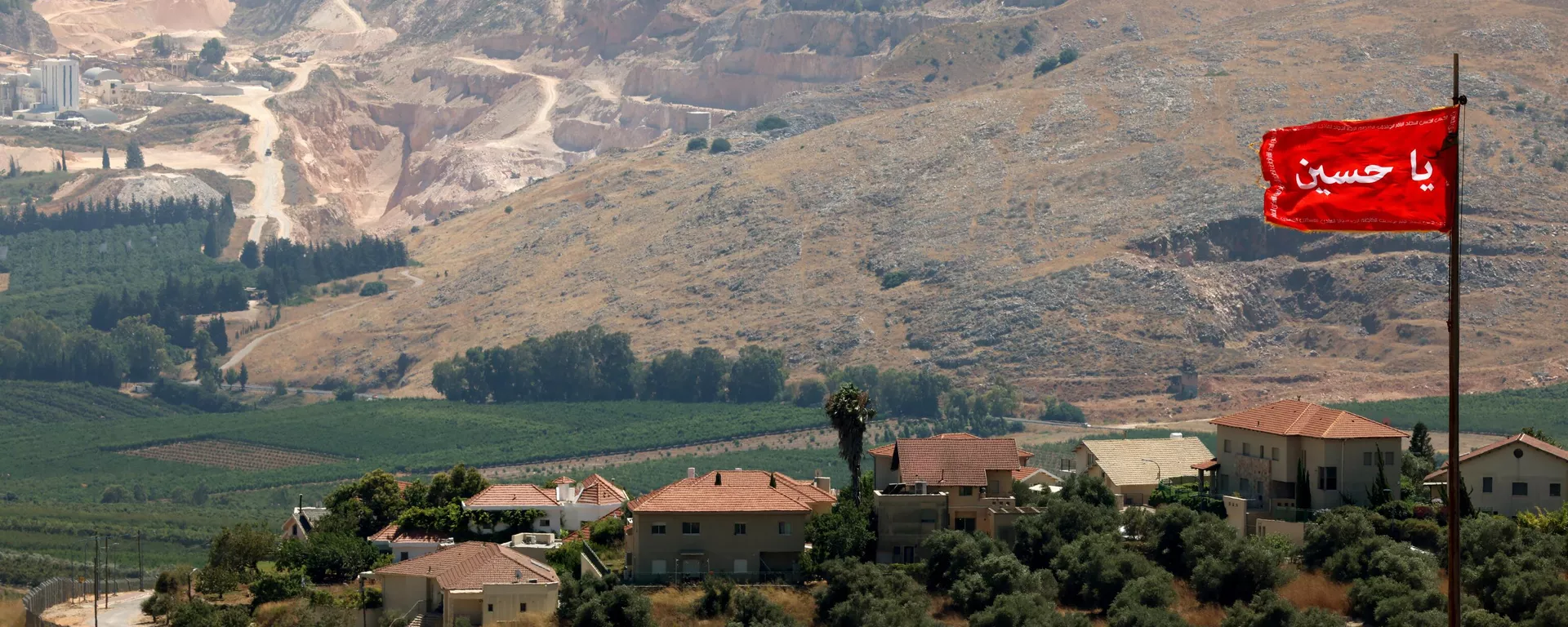 علم أحمر مكتوب عليه يا حسين يرفرف في سهل الخيام جنوب لبنان ، مقابل بلدة المطلة شمال إسرائيل في الصورة في الخلفية في 21 يوليو 2023. - سبوتنيك عربي, 1920, 12.03.2024