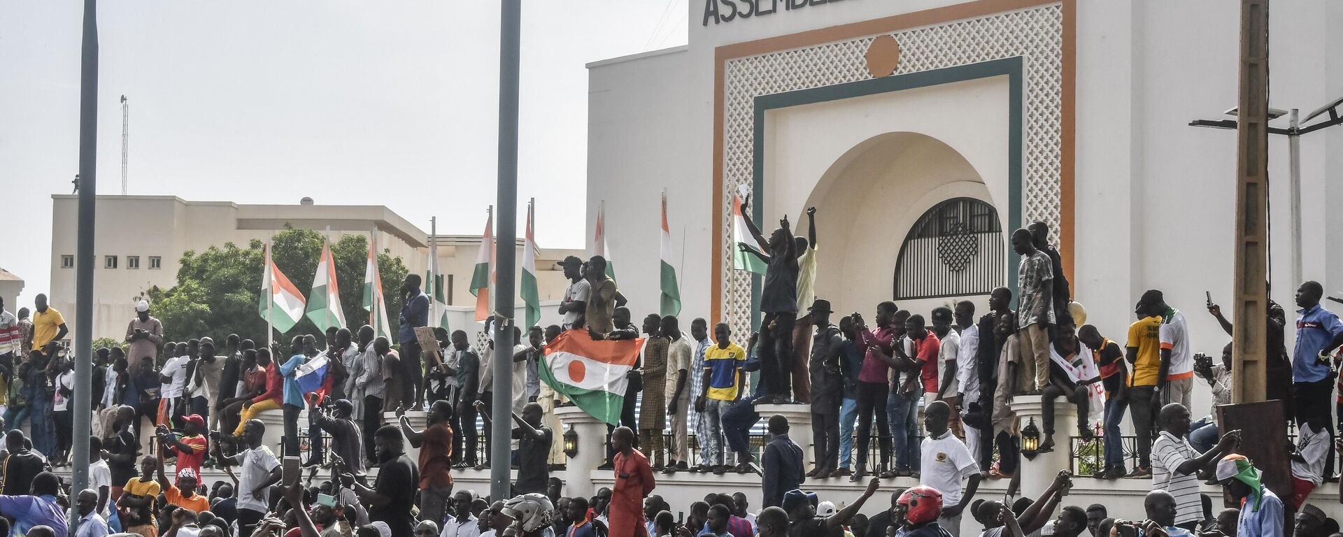 الوضع في النيجر -أنصار يلوحون بالأعلام النيجيرية أثناء احتشادهم لدعم المجلس العسكري النيجيري أمام مبنى الجمعية الوطنية في نيامي - سبوتنيك عربي, 1920, 10.08.2023