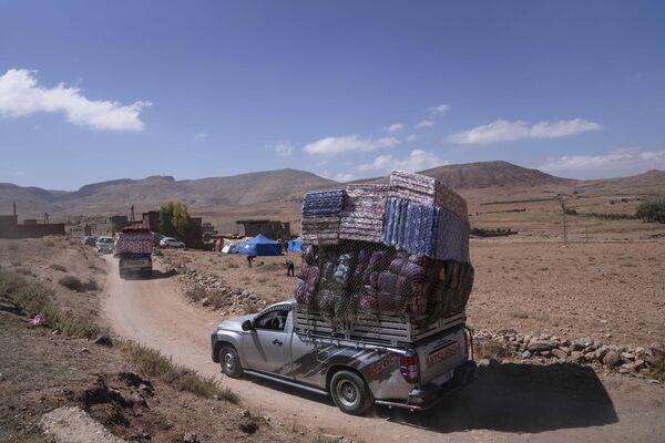 شاحنات تحمل مساعدات إنسانية تمر عبر قرية نائية تضررت من الزلزال، في بلدة دوزرو، خارج مراكش، المغرب، 13 سبتمبر 2023. - سبوتنيك عربي