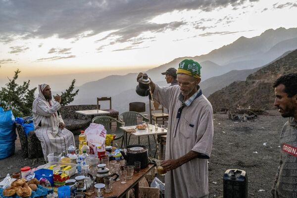 أحمد الحافظي (على اليمين) البالغ من العمر 63 عامًا يقدم الطعام مجانًا للناجين من الزلزال بالقرب من دار ضيافته المدمرة في سلسلة جبال الأطلس في ولاية الحوز في 14 سبتمبر 2023. - سبوتنيك عربي