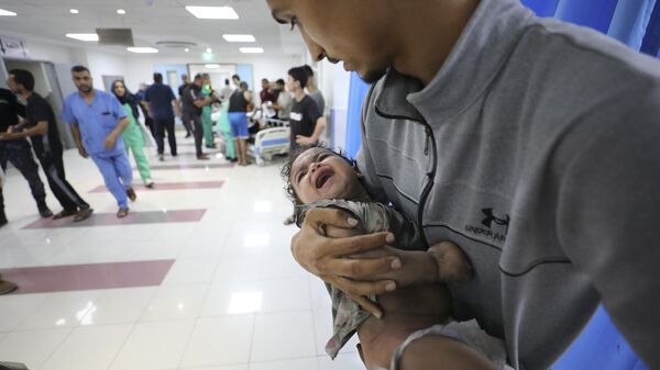 نقل طفل فلسطيني أصيب في غارات إسرائيلية إلى مستشفى الشفاء بغزة، 11 أكتوبر/ تشرين الأول 2023 - سبوتنيك عربي