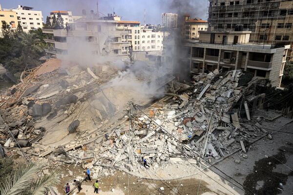 دخان يتصاعد من أنقاض مبنى دمرته غارة جوية إسرائيلية في مدينة غزة، قطاع غزة 8 أكتوبر 2023.  - سبوتنيك عربي