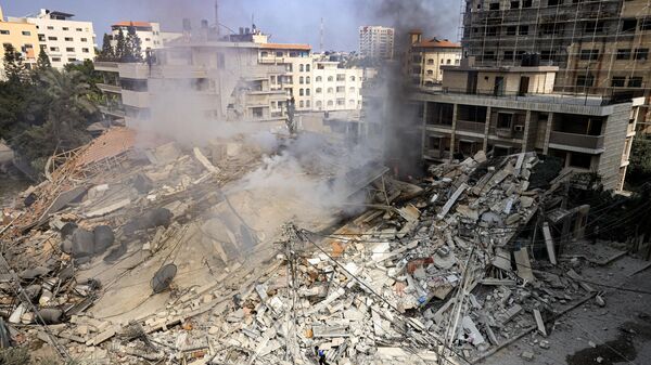 دخان يتصاعد من أنقاض مبنى دمرته غارة جوية إسرائيلية في مدينة غزة، قطاع غزة 8 أكتوبر 2023.  - سبوتنيك عربي