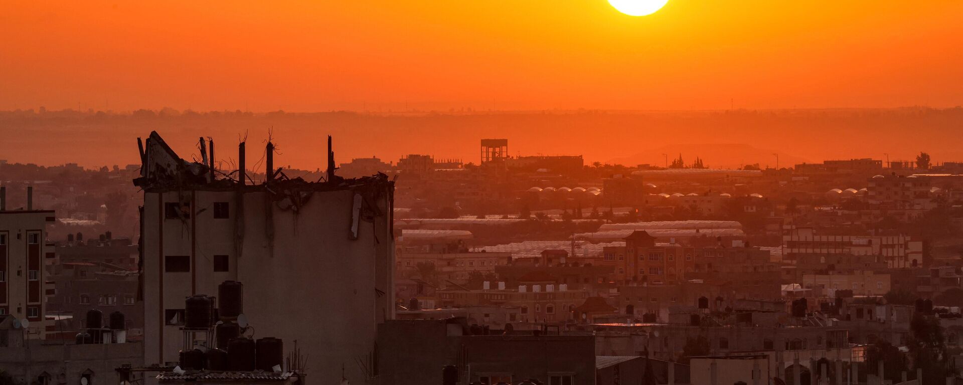 شروق الشمس على خلفية مبنى متضرر في أفق خان يونس في جنوب قطاع غزة، 19 أكتوبر 2023. - سبوتنيك عربي, 1920, 04.11.2023