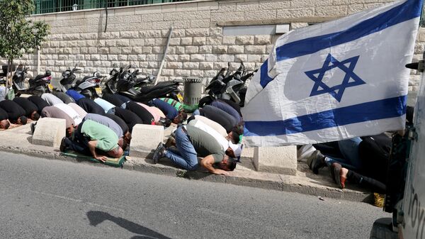 مسلمون يؤدون صلاة ظهر الجمعة في أحد شوارع حي رأس العمود بالقدس في 20 أكتوبر، 2023، بعد أن منعتهم قوات الأمن الإسرائيلية من دخول مجمع المسجد الأقصى  - سبوتنيك عربي