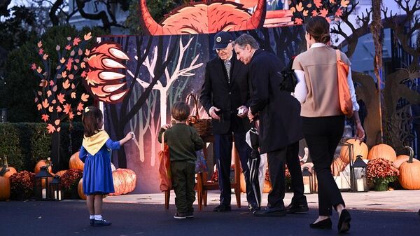 الرئيس الأمريكي، جو بايدن، يوزع الحلوى على أطفال وزير الخارجية الأمريكي، أنتوني بلينكن، خلال احتفال بعيد الهالوين بالبيت الأبيض، 30 أكتوبر/ تشرين الأول 2023 - سبوتنيك عربي