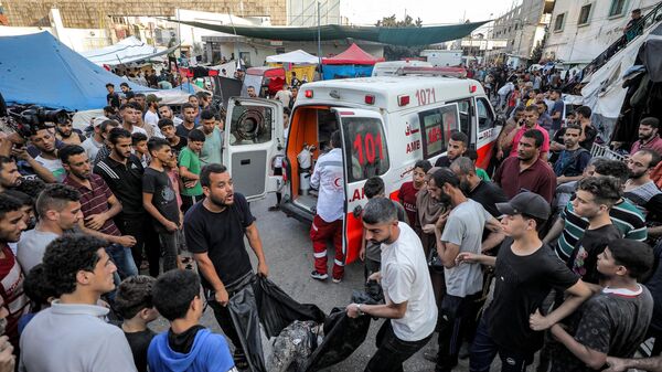 إخراج جثمان أحد الضحايا الذين قُتلوا في القصف الإسرائيلي من سيارة إسعاف تصل إلى مستشفى الشفاء في مدينة غزة في 2 نوفمبر 2023 - سبوتنيك عربي
