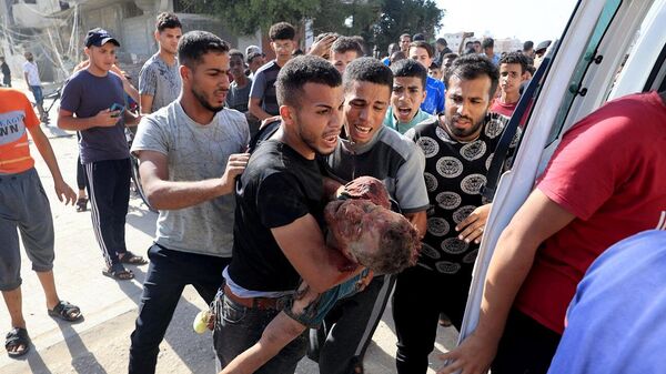 فلسطيني ينقل رجلا مصابا إلى سيارة إسعاف كانت تنتظره، بعد غارة إسرائيلية على مدينة رفح، جنوب قطاع غزة، 9 نوفمبر/ تشرين الثاني 2023 - سبوتنيك عربي