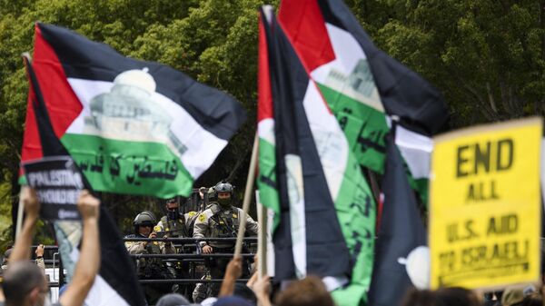نواب إدارة شرطة لوس أنجلوس يشاهدون الناس يتظاهرون دعمًا لفلسطين في 15 مايو 2021 في لوس أنجلوس - أمريكا.  - سبوتنيك عربي