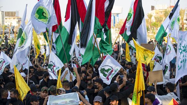 أنصار حزب الله اللبناني يلوحون بالأعلام في ساحة التحرير بالعاصمة العراقية بغداد، 3 نوفمبر 2023 - سبوتنيك عربي