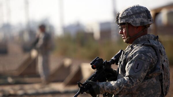 جندي أمريكي يحرس قاعدة التاجي الذي يستضيف القوات العراقية والأمريكية ويقع على بعد ثلاثين كيلومترا شمال العاصمة بغداد في 29 ديسمبر 2014 - سبوتنيك عربي
