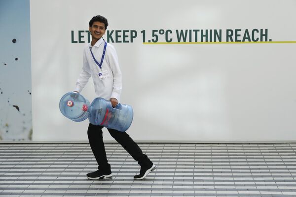 رجل يحمل حاويات مياه قبل قمة المناخ التابعة للأمم المتحدة COP28، في دبي, الإمارات العربية المتحدة، 29 نوفمبر 2023 - سبوتنيك عربي