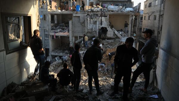 تجدد قصف الجيش الإسرائيلي على قطاع غزة، فلسطينيون يتفقدون الدمار الذي لحق بالمباني السكنية في أعقاب الغارات الجوية الإسرائيلية على مخيم رفح للاجئين في جنوب قطاع غزة في 1 ديسمبر كانون الأول 2023, - سبوتنيك عربي