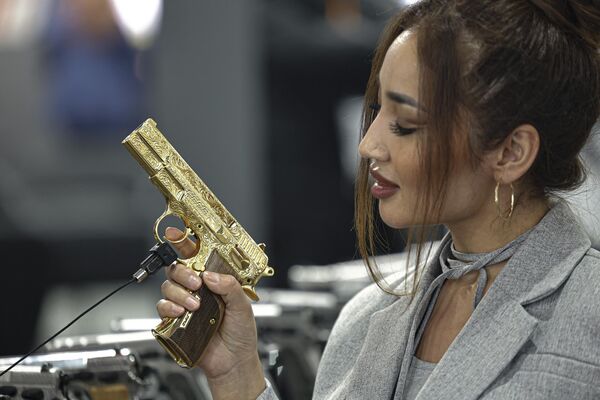 زائرة من كازاخستان تتفقد مسدسًا خلال يوم افتتاح الدورة الثالثة لمعرض مصر الدفاعي (EDEX-2023)، بحضور 111 دولة مشاركة، في مركز القاهرة الدولي للمعارض، في القاهرة في 4 ديسمبر 2023 - سبوتنيك عربي