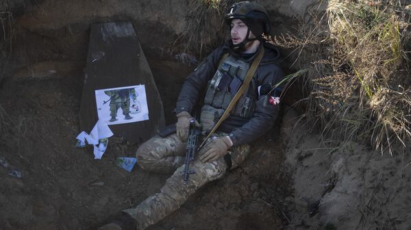 جندي أوكراني يجلس في خندق في شمال أوكرانيا - سبوتنيك عربي