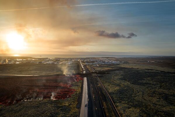 يُظهر منظر جوي تم التقاطه في 14 يناير 2024 الحمم البركانية المتدفقة بالقرب من الطريق المؤدي إلى مدينة غريندافيك في جنوب غربي أيسلندا بعد ثوران بركان. - سبوتنيك عربي