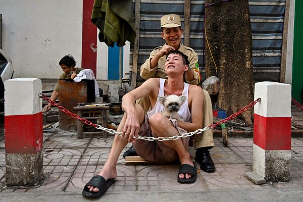 في حركة طريفة، رجل يزيل الشعر الأبيض لصديقه في شارع هانوي، فيتنام، في 18 يناير 2024. - سبوتنيك عربي