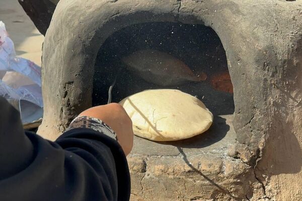 نازحة فلسطينية تصنع الخبز على فرن الطين القديم لإطعام أسرتها ومساعدة النازحين - سبوتنيك عربي