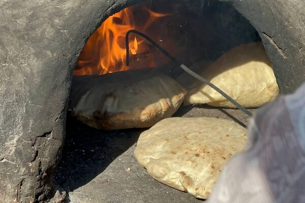 نازحة فلسطينية تصنع الخبز على فرن الطين القديم لإطعام أسرتها ومساعدة النازحين - سبوتنيك عربي