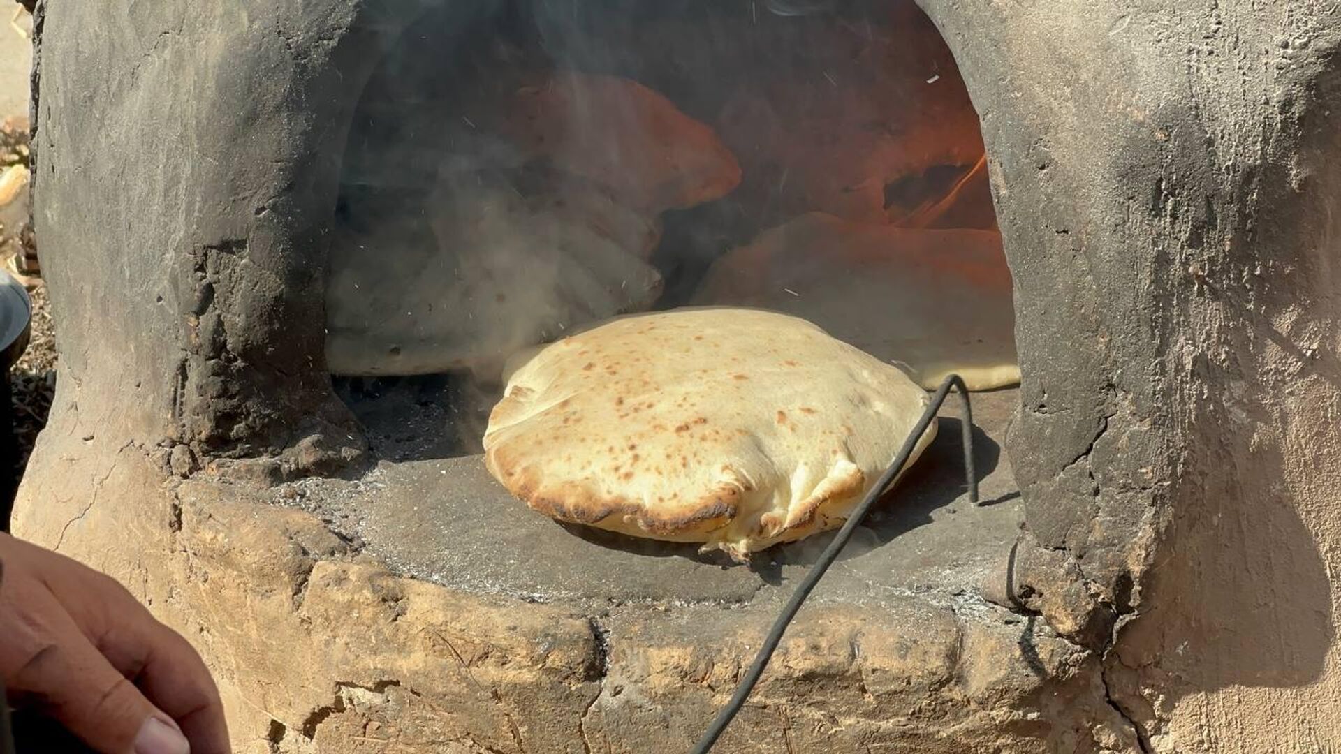 نازحة فلسطينية تصنع الخبز على فرن الطين القديم لإطعام اسرتها ومساعدة النازحين - سبوتنيك عربي, 1920, 22.01.2024