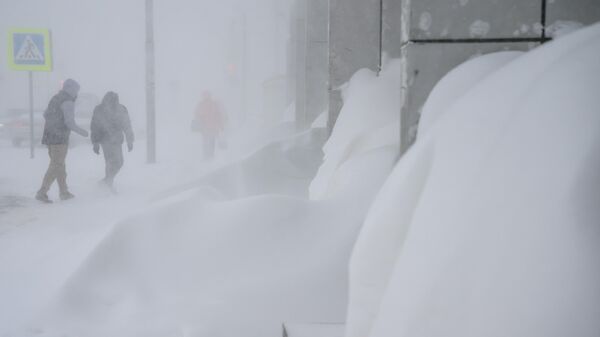 مواطنون في أحد شوارع جنوب ساخالينسك أثناء تساقط الثلوج الكثيف  - سبوتنيك عربي