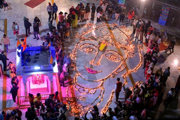 المصلون يقفون مصابيح زيتية خفيفة لتصوير الإله الهندوسي رام في معبد دورجيانا في أمريتسار في 22 يناير 2024، بمناسبة حفل تكريس معبد أيوديا رام. - سبوتنيك عربي