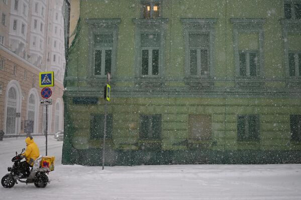 ساعي خدمة توصيل الطعام ياندكس أثناء تساقط الثلوج في موسكو، روسيا 7 فبراير 2024 - سبوتنيك عربي