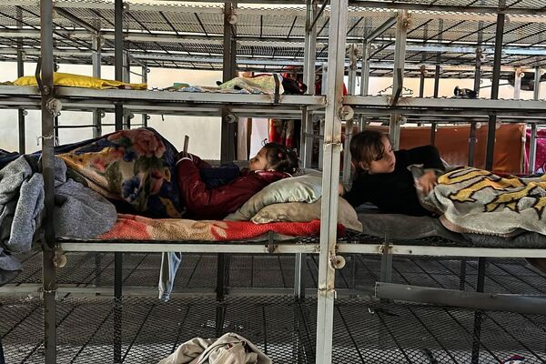 أطفال فلسطينيون ينامون داخل أقفاص مخصصة للدجاج نتيجة امتلاء الأماكن بالنازحين في رفح جنوب قطاع غزة - سبوتنيك عربي