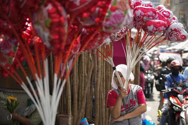 امرأة تبيع البالونات في سوق الزهور خلال عيد الحب يوم الأربعاء 14 فبراير 2024، في مانيلا، الفلبين. - سبوتنيك عربي