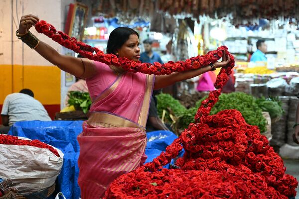 بائعة زهور تقوم بإعداد إكليل من الورود عشية عيد الحب في سوق في بنغالورو في 13 فبراير 2024. - سبوتنيك عربي