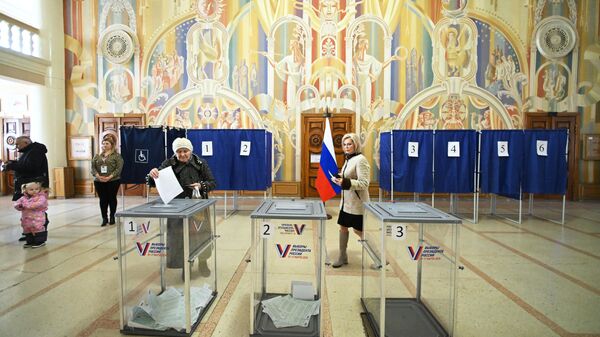 Люди голосуют на выборах президента России на избирательном участке в Луганске - سبوتنيك عربي
