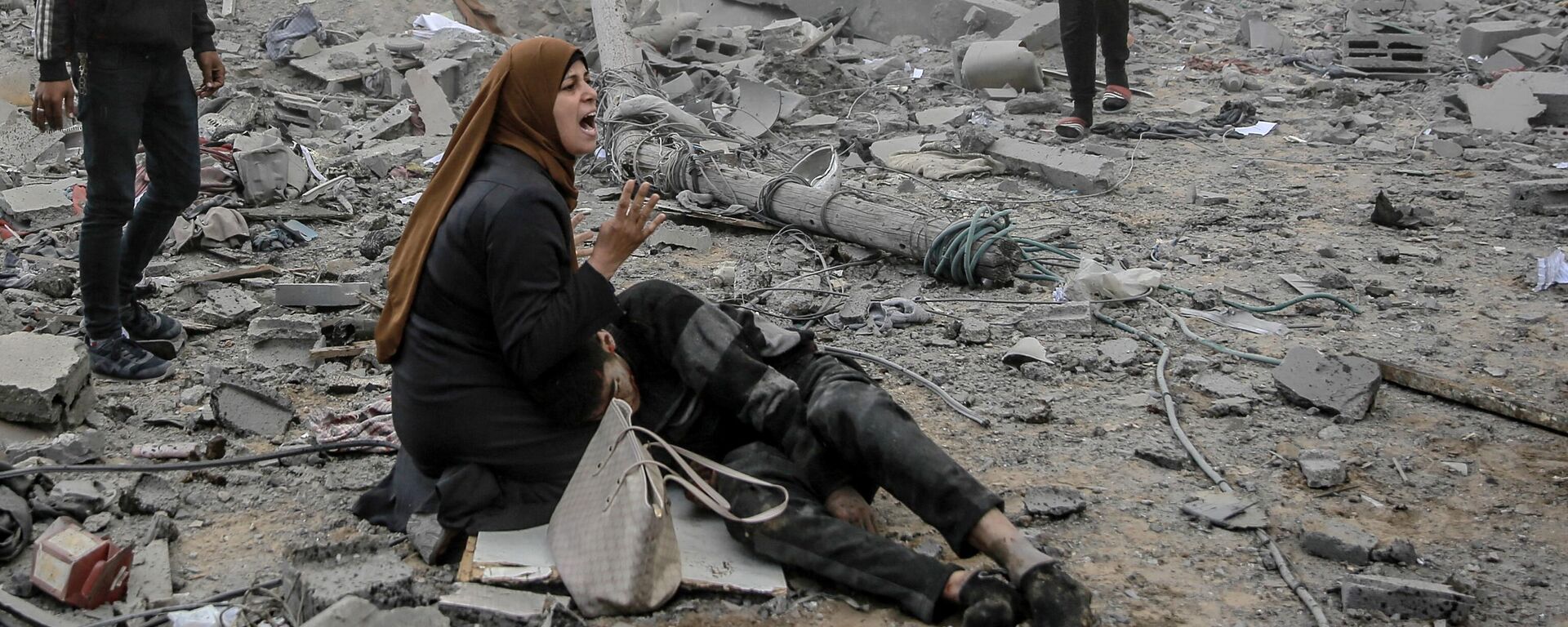 رد فعل امرأة فلسطينية وهي تحتضن طفلاً جريحًا بعد القصف الإسرائيلي على وسط مدينة غزة، فلسطين في 18 مارس 2024 - سبوتنيك عربي, 1920, 28.03.2024
