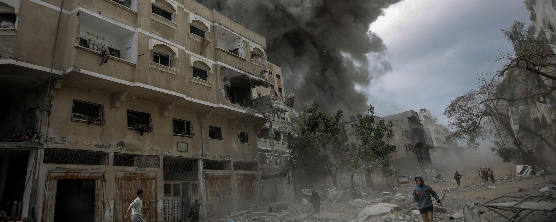 يندفع الفلسطينيون للاختباء بينما يتصاعد الدخان بعد القصف الإسرائيلي على وسط مدينة غزة، فلسطين 18 مارس 2024 - سبوتنيك عربي, 1920, 19.03.2024