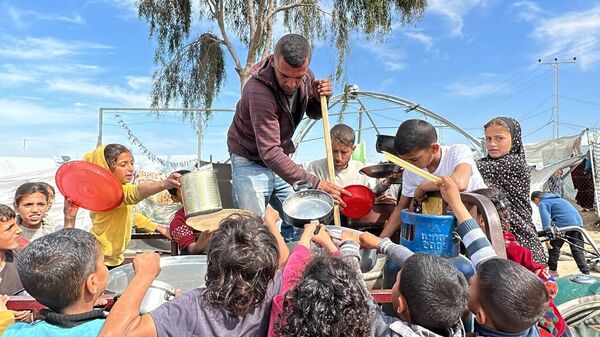 متطوعون يطهون الطعام على الحطب للنازحين في رفح جنوب قطاع غزة - سبوتنيك عربي
