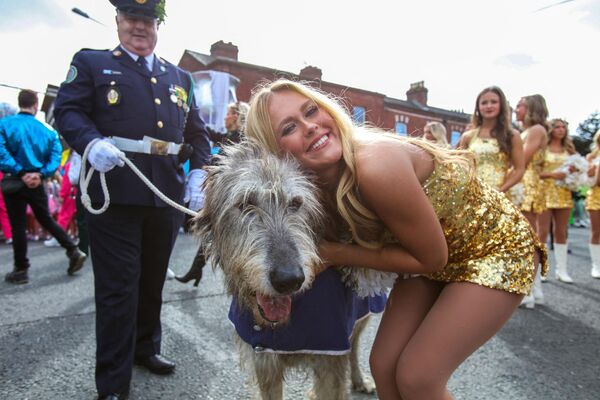 فرقة Golden Girls الموسيقية الأمريكية، تقف مع الكلبة الأيرلندية  قبل العرض خلال العرض السنوي لعيد القديس باتريك في دبلن الإيرلندية. - سبوتنيك عربي