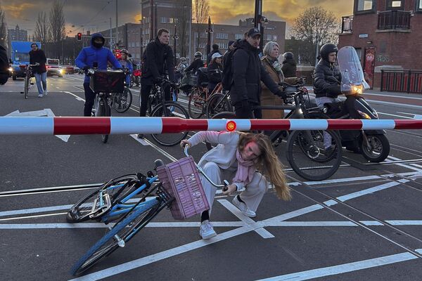 راكب دراجة يمر تحت الحواجز المغلقة للحاجز المعطل في أمستردام الهولندية. - سبوتنيك عربي