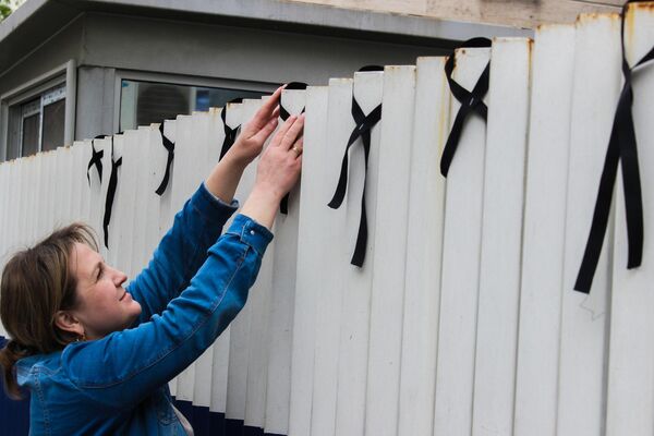 أطفال سوريون يعلقون شارات الحداد على جدار البيت الروسي حزنا على ضحايا كروكوس - سبوتنيك عربي