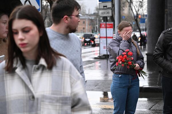 الناس يبكون عند نصب تذكاري مؤقت أمام السفارة الروسية في يريفان، أرمينيا، في 23 مارس 2024، بعد يوم واحد من هجوم مسلح على قاعة &quot;كروكوس سيتي&quot; بضواحي موسكو. - سبوتنيك عربي
